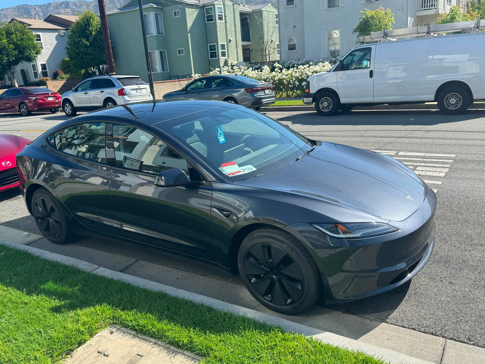 Grey Tesla Model 3 parked at the kerb